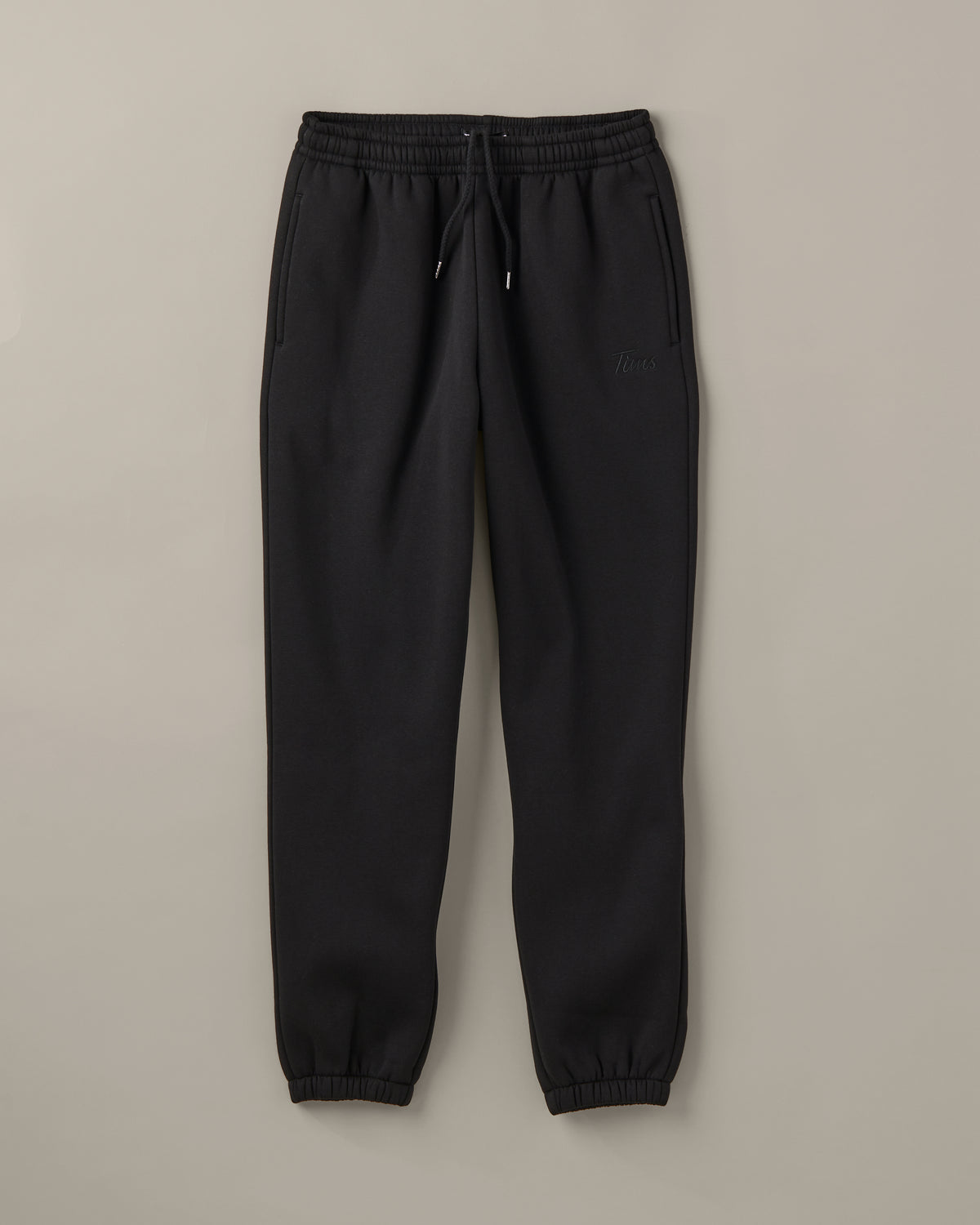 Black unisex joggers with a drawstring waist, cuffed ankles and a small graphic at the hip. | Pantalon en coton ouaté unisexe noir avec lacet de serrage à la taille, chevilles côtelées et petite image sur la hanche. - Image #2