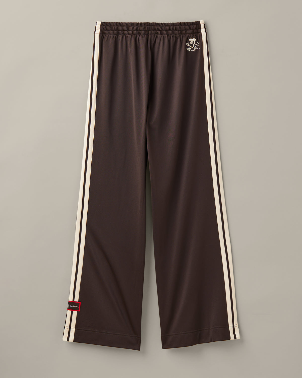 Women’s wide-leg espresso-brown adidas® track pants with cream 3-Stripes and red co-branded details. - Image #3