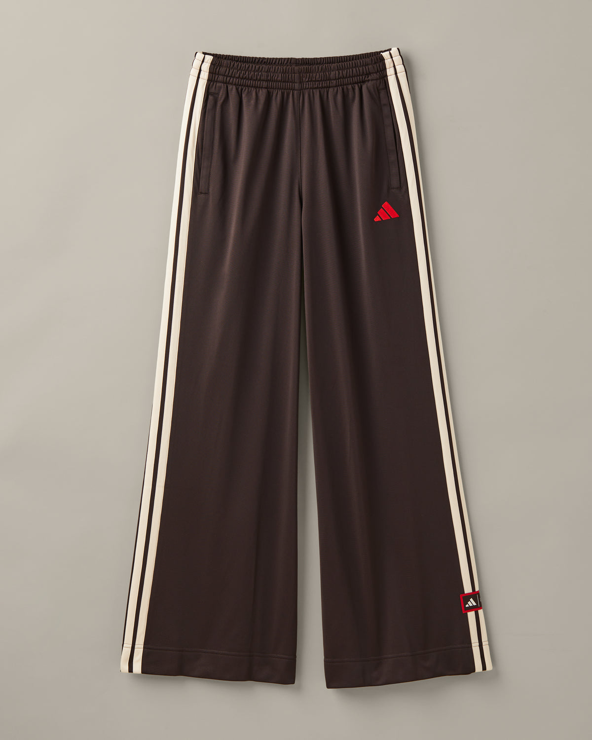 Women’s wide-leg espresso-brown adidas® track pants with cream 3-Stripes and red co-branded details. - Image #2
