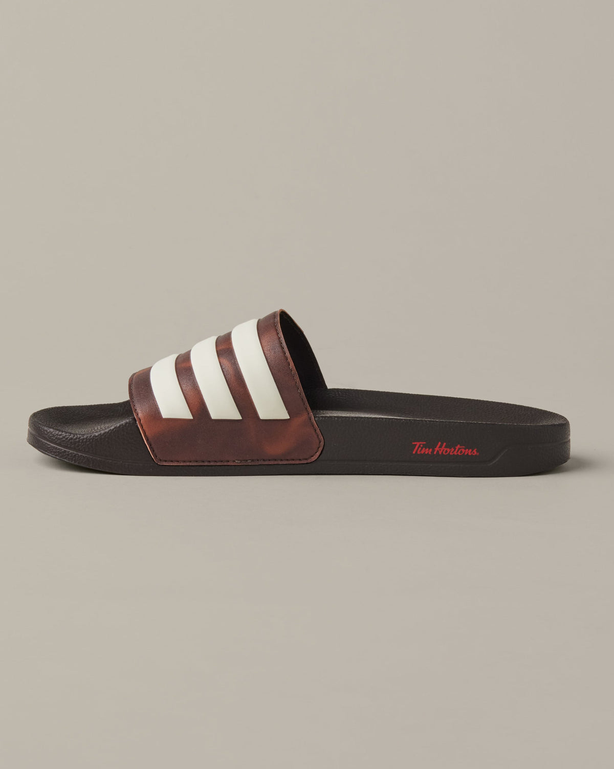 Espresso-brown adidas® Adilette Aqua slides with cream 3-Stripes across the foot straps. - Image #3