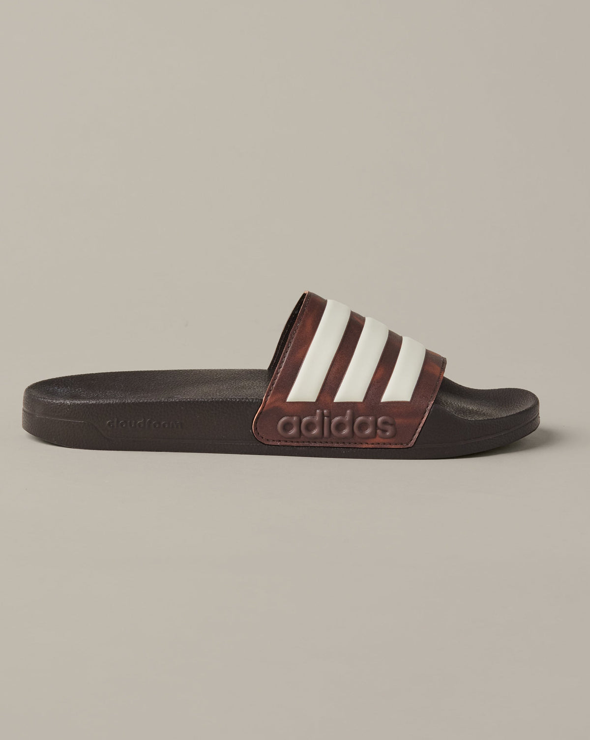 Espresso-brown adidas® Adilette Aqua slides with cream 3-Stripes across the foot straps. - Image #4