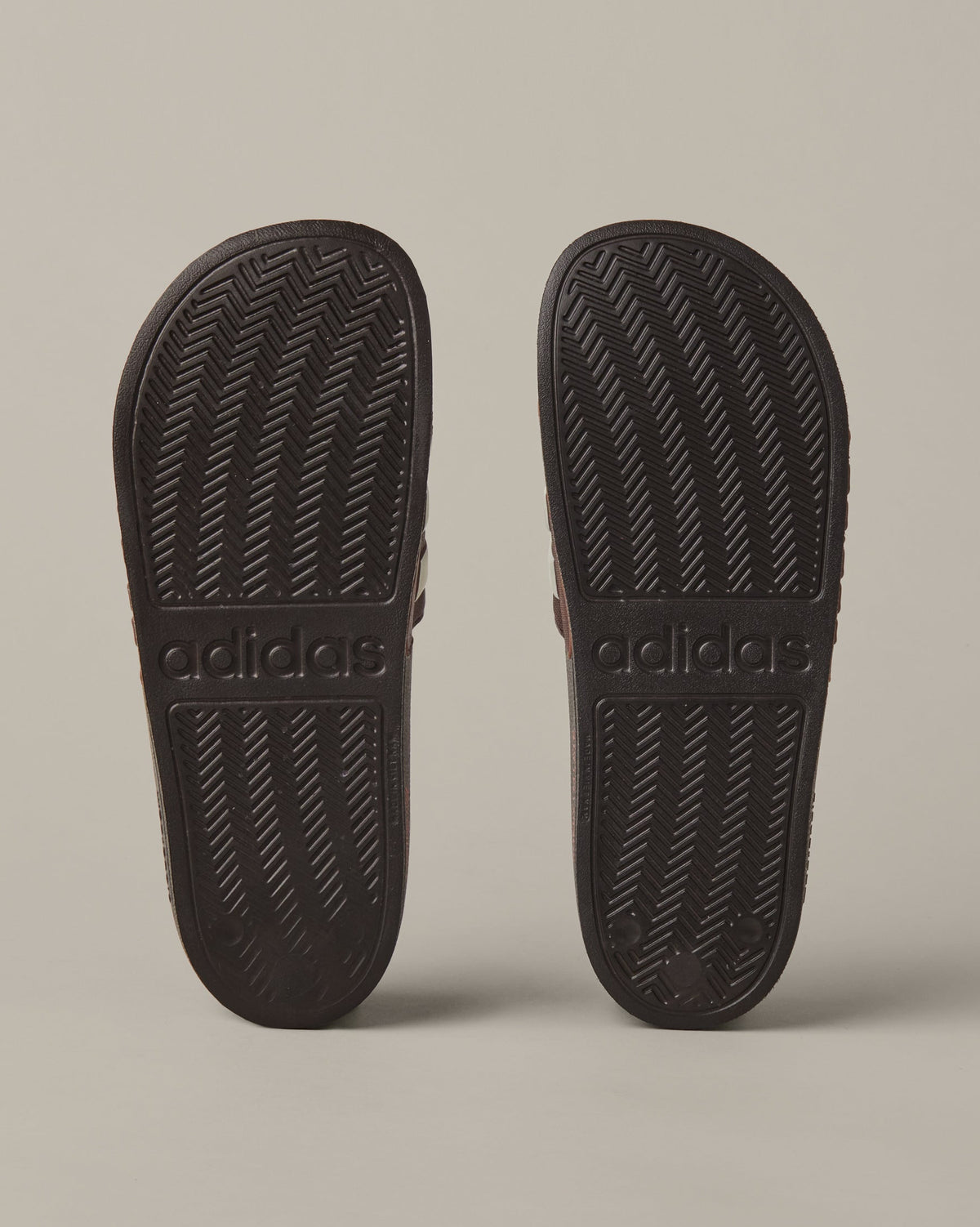 Espresso-brown adidas® Adilette Aqua slides with cream 3-Stripes across the foot straps. - Image #5