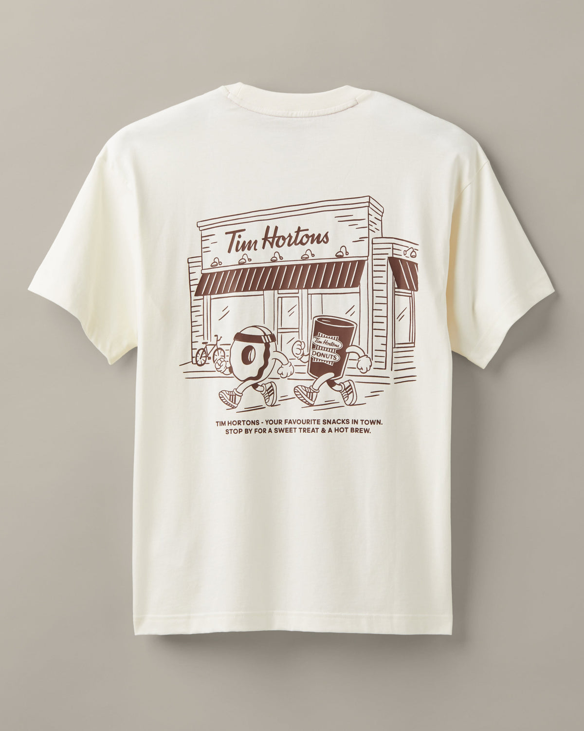 Cream unisex T-shirt featuring coffee-and-donut characters running past a classic Tim Hortons restaurant. - Image #3